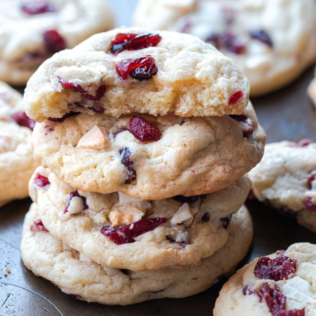 A stack of soft and chewy sugar cookies with cranberries and white chocolate.