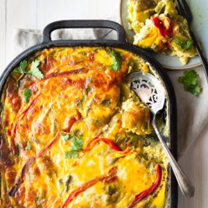 Hatch green Chile Casserole in a cast iron pan and a serving on the side on a plate