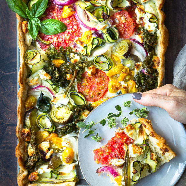 A savory garden veggie tart with tomatoes, zucchini, onion, and kale.